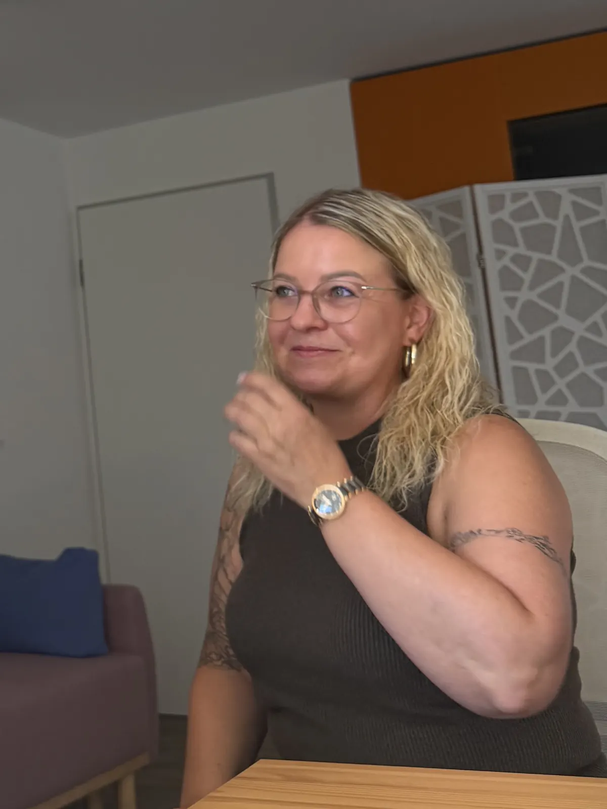 Mariana Bauer sitzt lächelnd am Tisch und hört zu.